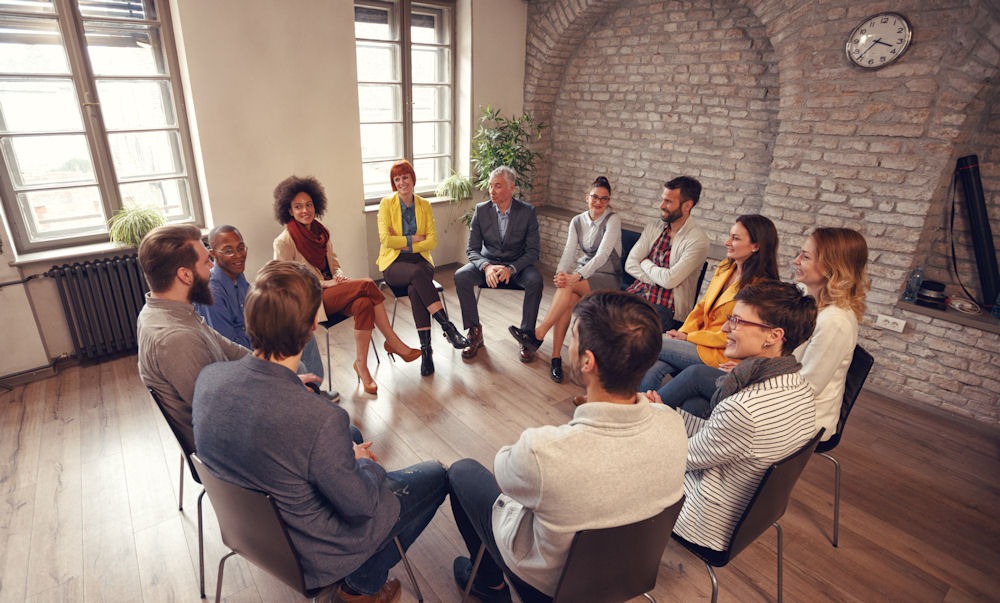 a group of people sitting in circle during therapy