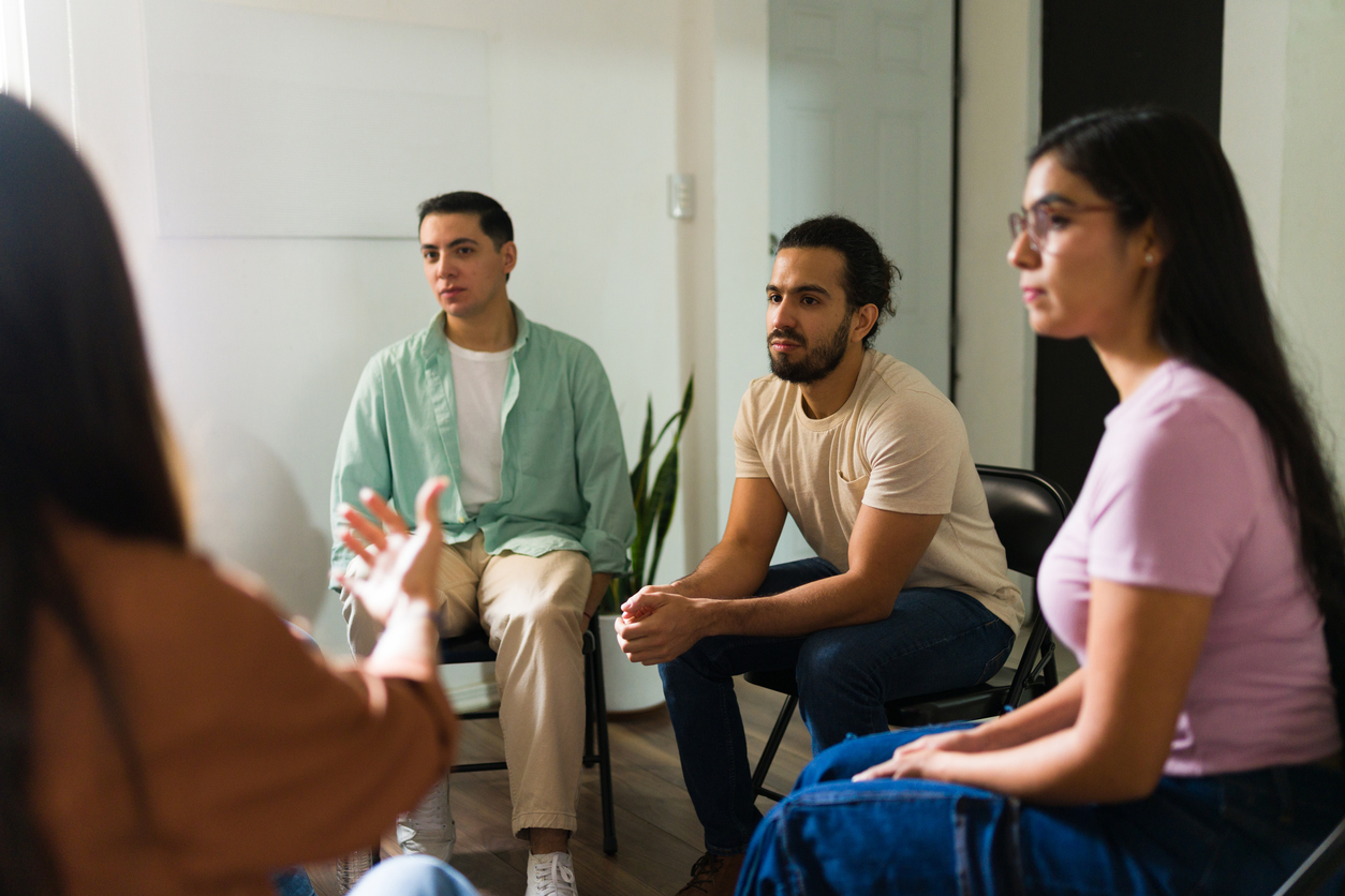 Adults participating in a therapist-led group session as part of a partial hospitalization program in Texas.