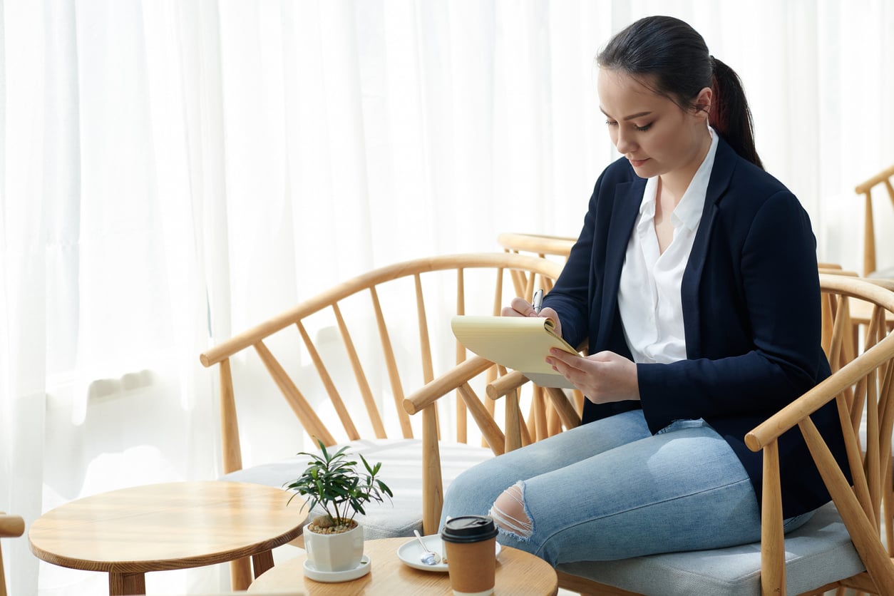 Woman writing notes as she prepares for a compassionate conversation about addiction and getting help.