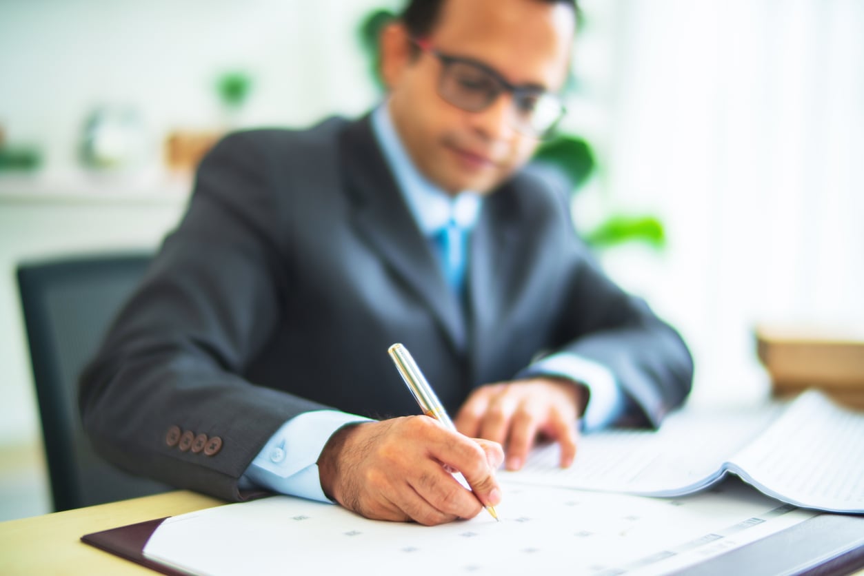 Working professional reviewing paperwork while planning confidential medical leave for addiction treatment.