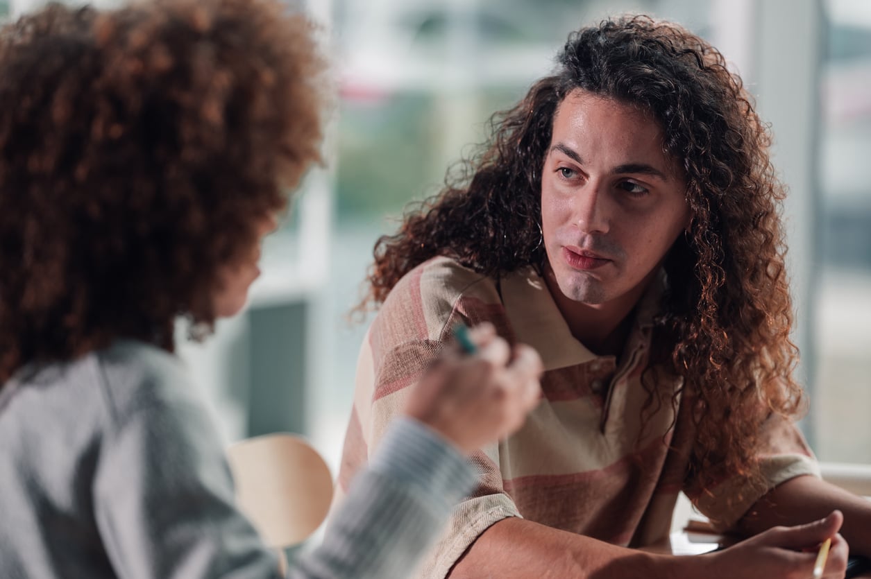 Adult man listening during a calm, supportive conversation about addiction and getting help.
